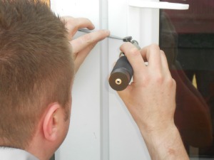 A locksmith working on a door